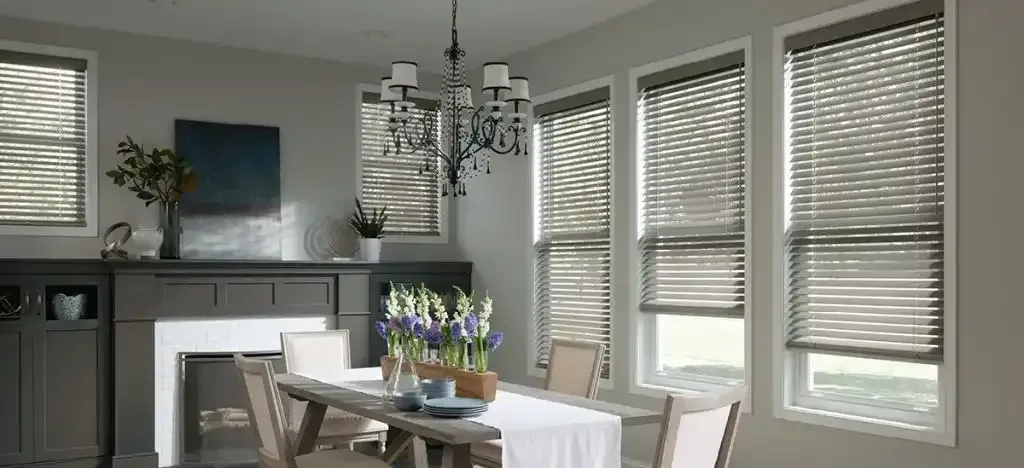 Dining room with a table set for a meal, fireplace, and windows with blinds.