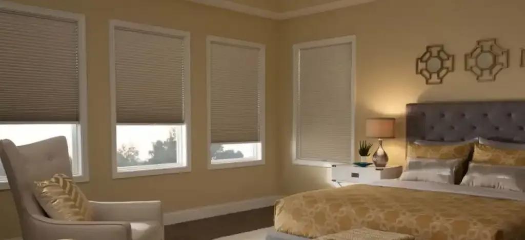 Bedroom with beige walls and three windows fitted with custom blinds
