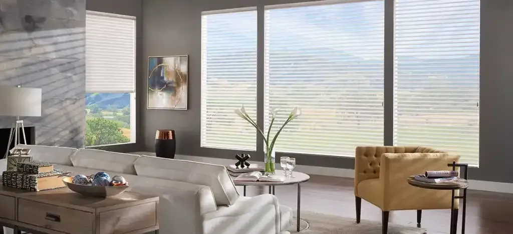 Living room with white sofa, yellow armchair, large window with blinds, and decorative accents.