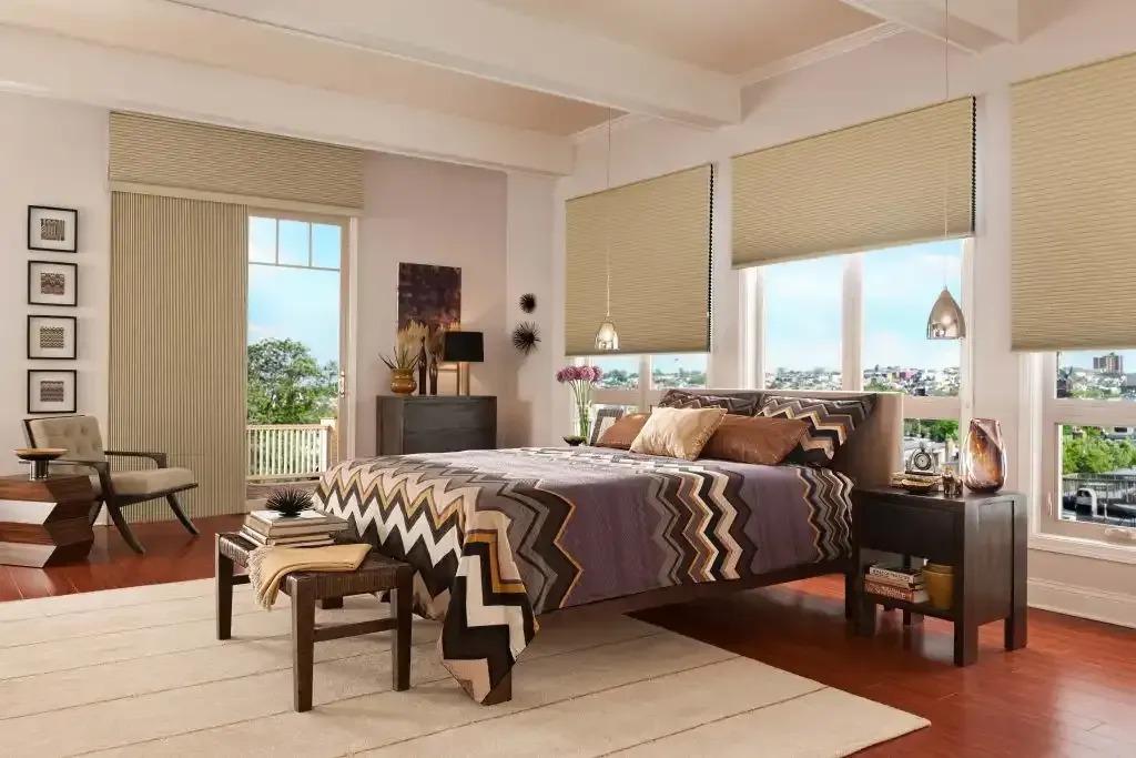Bedroom with chevron bedding and tan cellular shades raised on large windows
