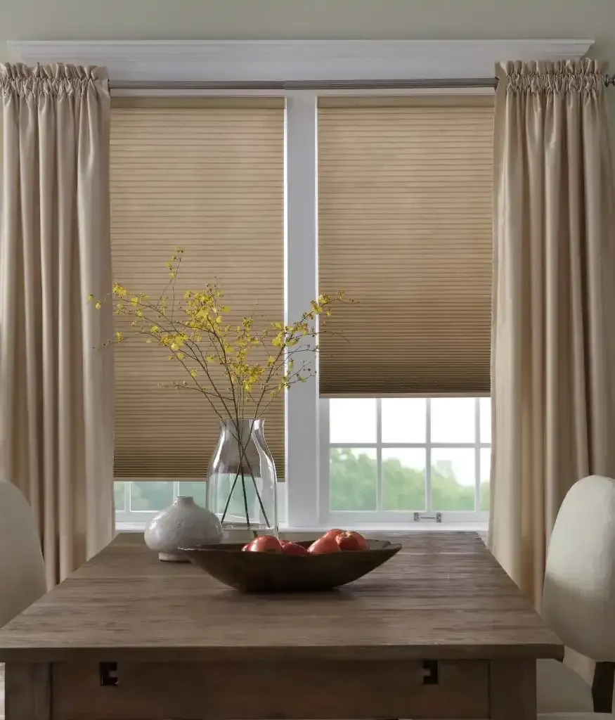 Dining room with cellular shades and side curtains on the windows