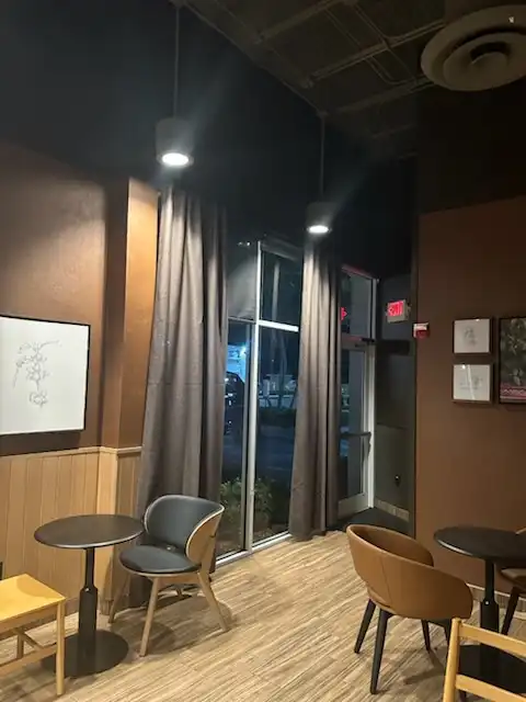 Gray drapery panels hung beside a cafe's glass entrance door and tall storefront windows