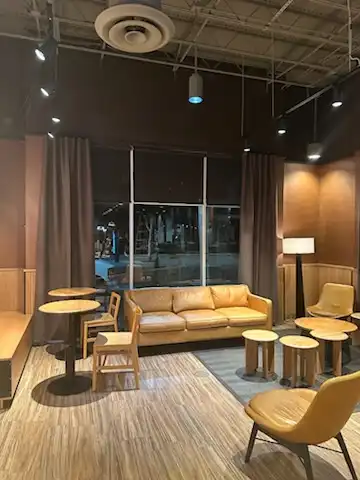 Gray drapery panels framing a large window behind a leather sofa in a cafe lounge