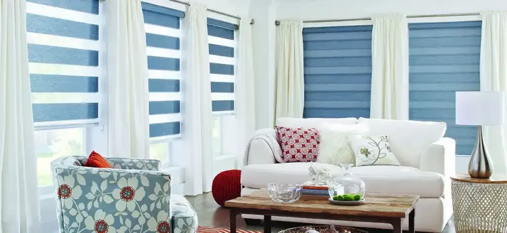 Living room with a white sofa, white curtains, and blue dual zebra shades