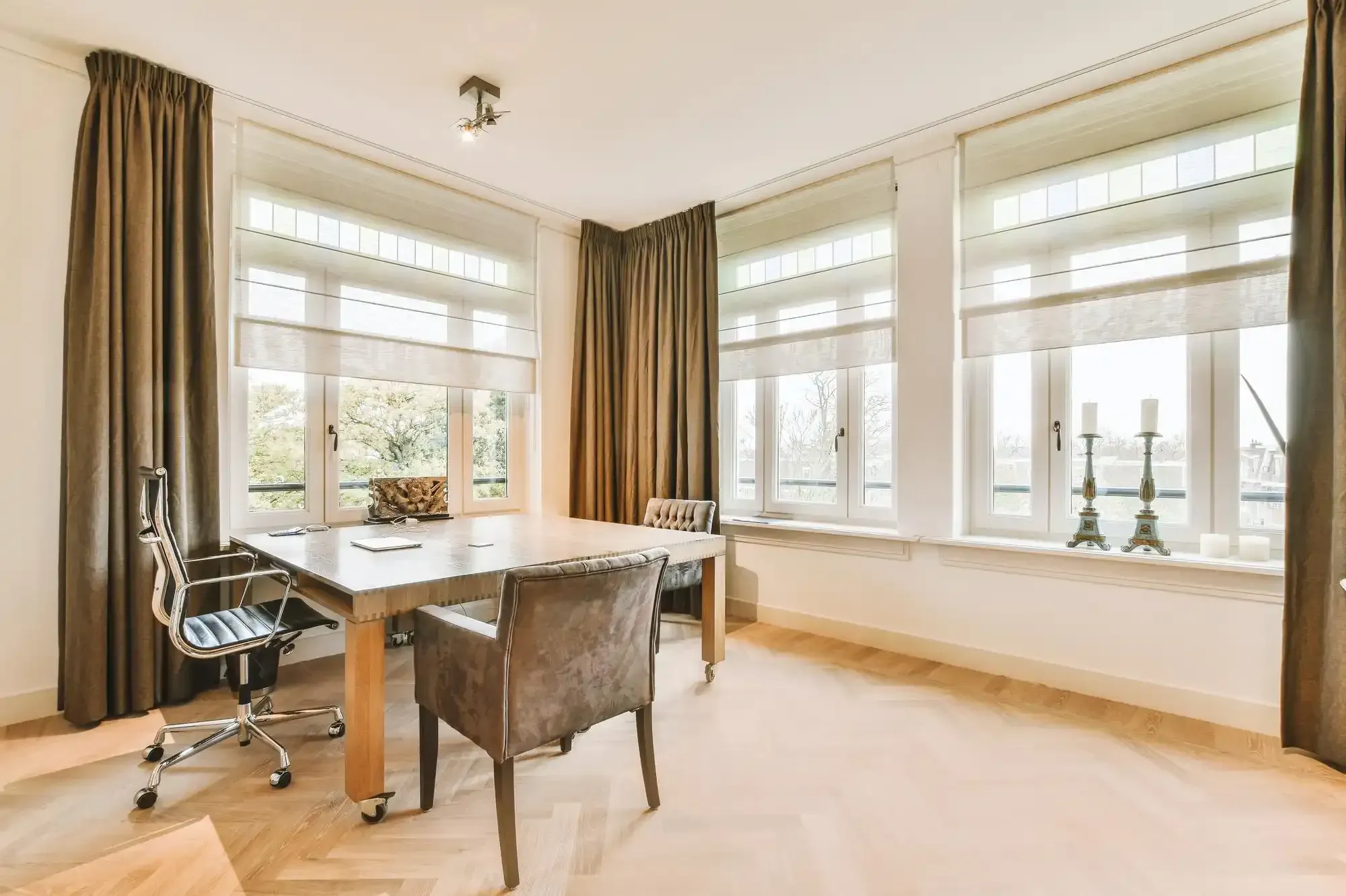 Home office with light-filtering shades on tall white windows