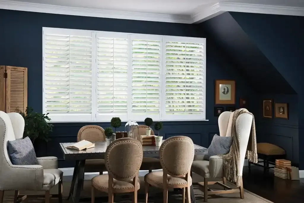Navy dining room with white plantation shutters on the windows