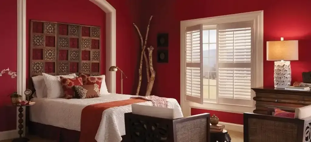 Bedroom with red walls and white plantation shutters