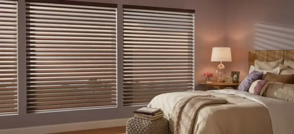 Bedroom with mauve walls and brown sheer shadings closed on wide windows
