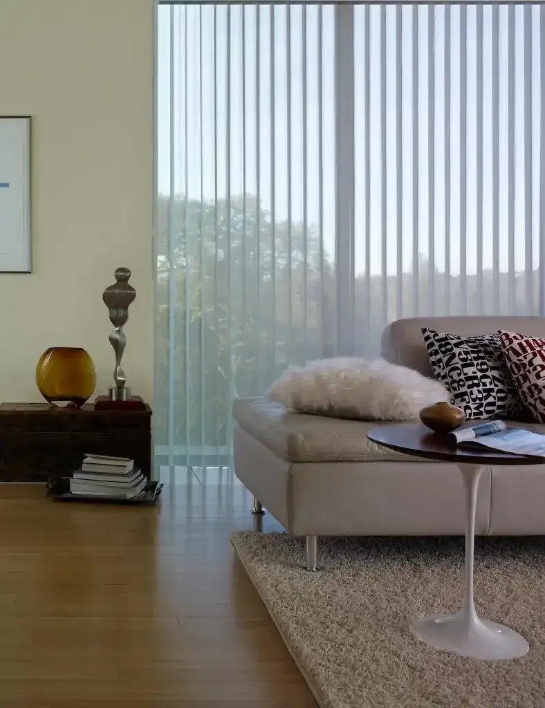 Living room with sheer vertical blinds drawn across the windows