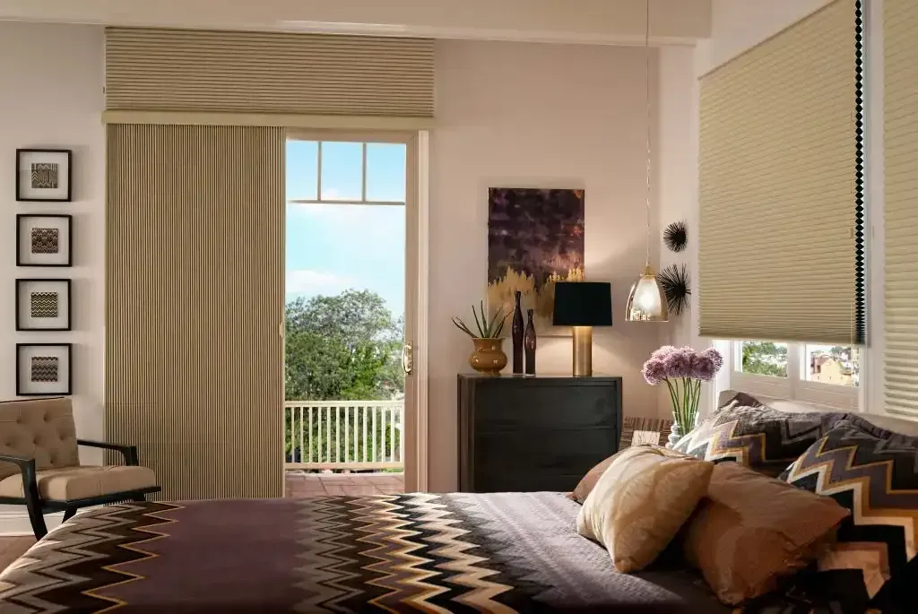 Bedroom with vertical cellular shades on a balcony door and a cellular shade on the window