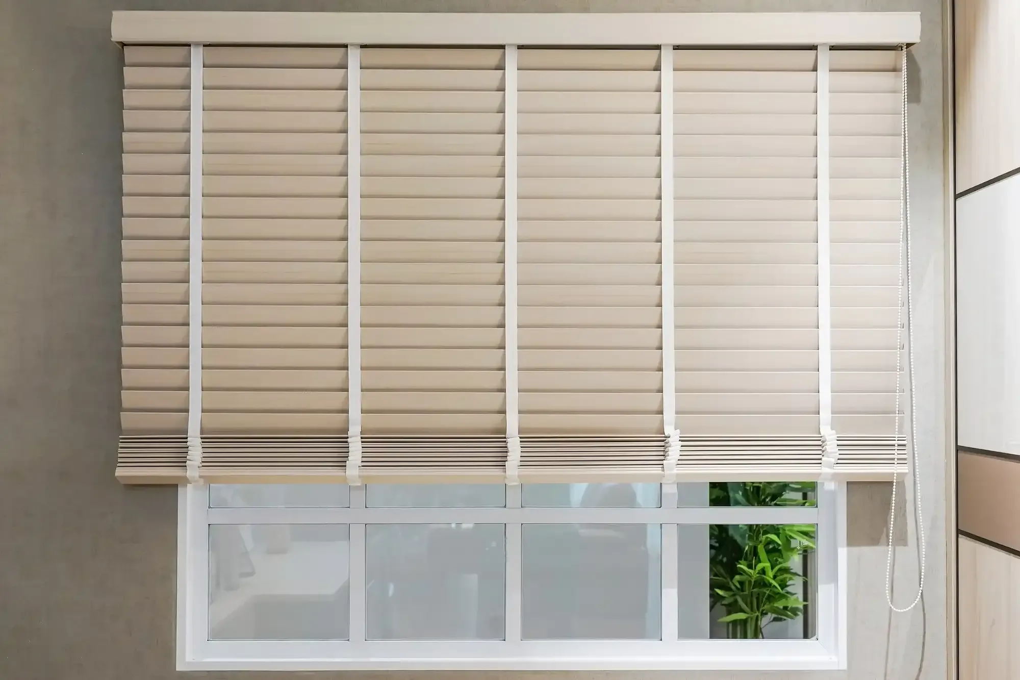 Close view of wood blinds with cloth tapes and a headrail